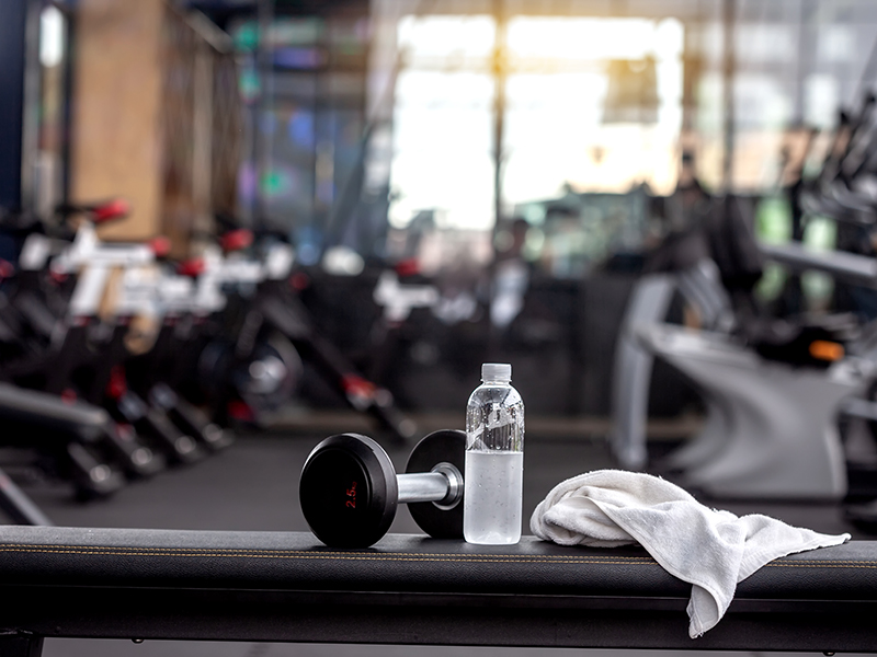 gym dumbbell, water and towel